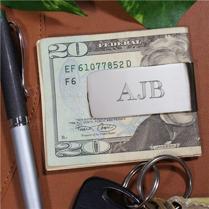 Engraved silver money clip holding folded cash, showcasing its durable, high-luster nickel-plated surface.