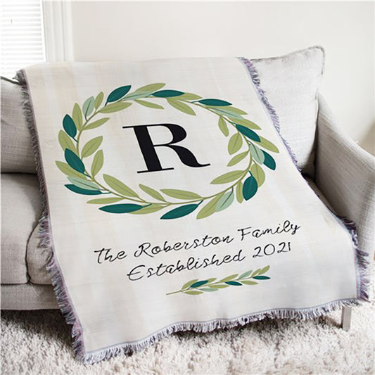Personalized woven afghan throw with green olive wreath and custom monogram, perfect for family or home decor