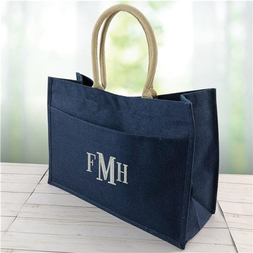 Navy jute tote bag featuring white embroidered initials and structured silhouette