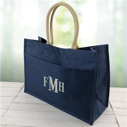 Navy jute tote bag featuring white embroidered initials and structured silhouette